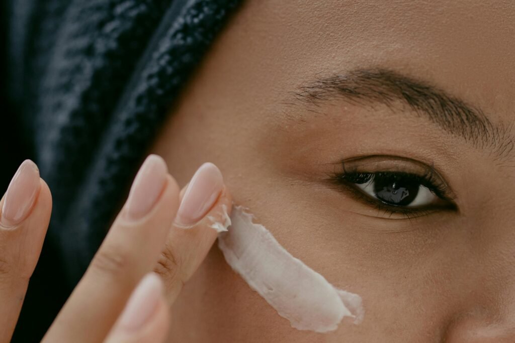 Femme qui met de la crème sur son visage